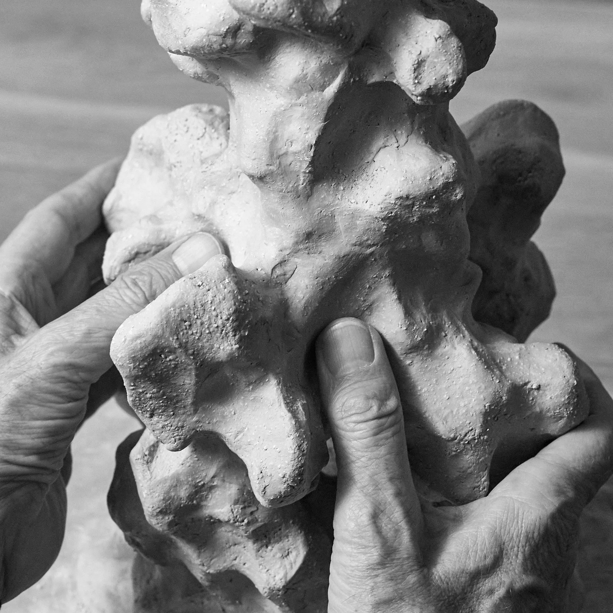 Las manos de Alexander Tinti moldeando una escultura de arcilla